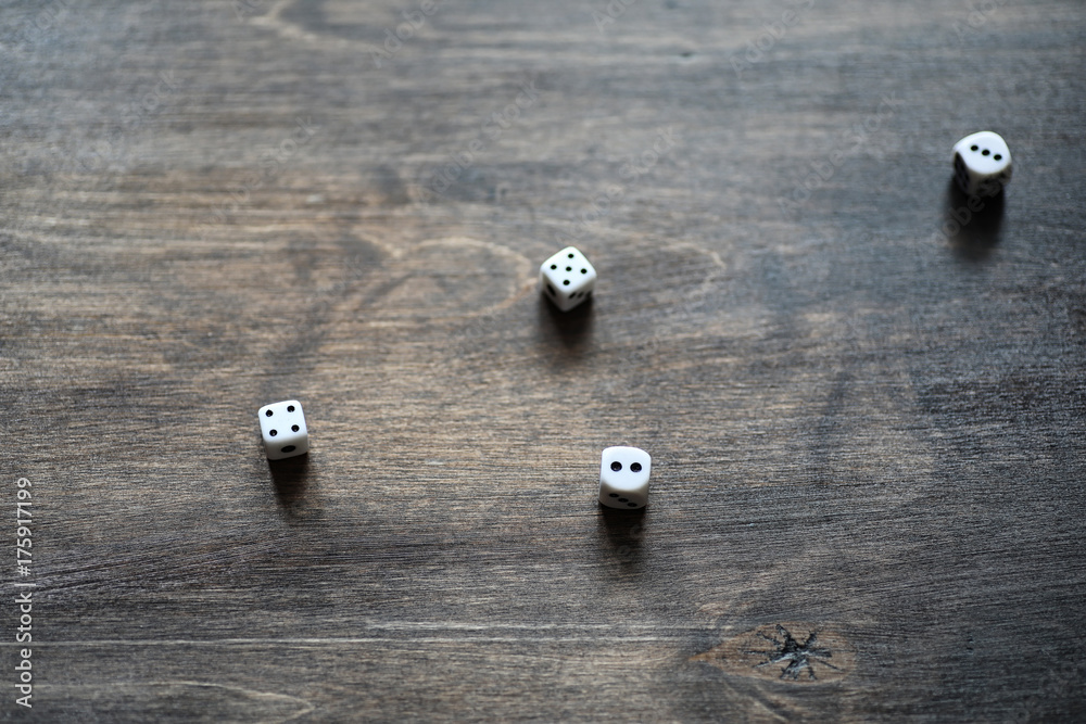 White dices on a brown wooden texture table White dices on a brown wooden texture table
