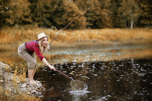Girl in autumn with a fishing rod