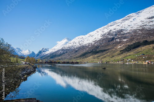 Fjord with snow capped mountains mirrored in water