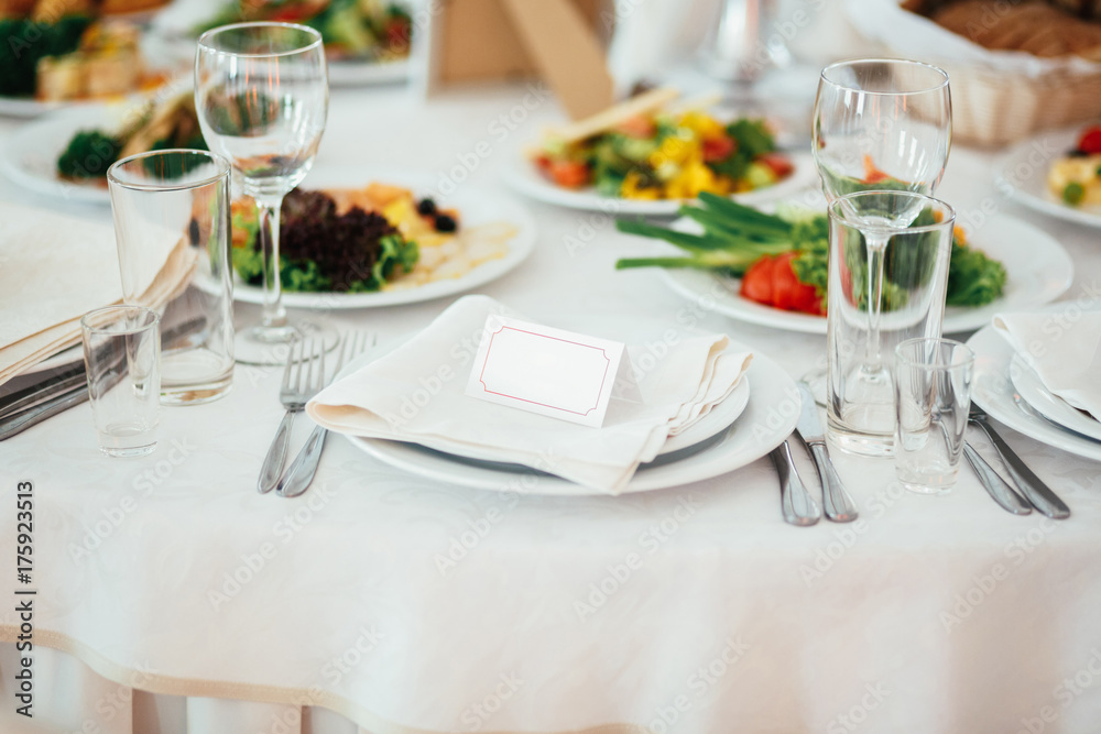 Empty card for guest name put on a dinner plate