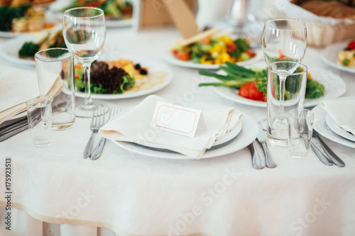 Empty card for guest name put on a dinner plate