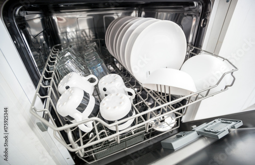 Open dishwasher with clean dishes close up