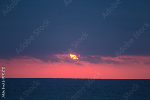 A calm sunset at the Baltic sea. Autumn evening at the beach. Sun and the sea horizon. A colorful landscape of a sea.