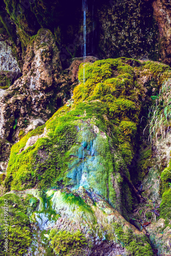 Photo of little waterfall flowing in cave photo