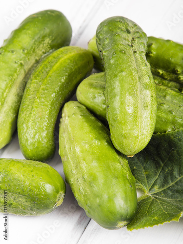 fresh organic cucumbers on a white wooden background.