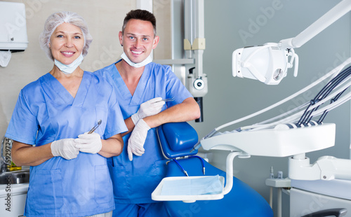 Two professional confident dentists near dental chair