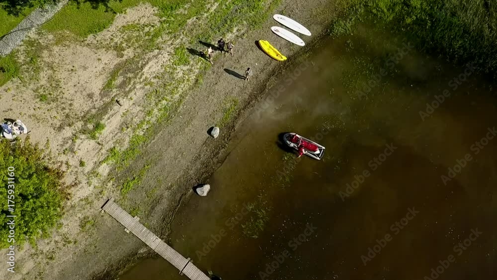 Man gets on seadoo at shore - slow motion aerial shot Man gets on seadoo at shore - slow motion aerial shot