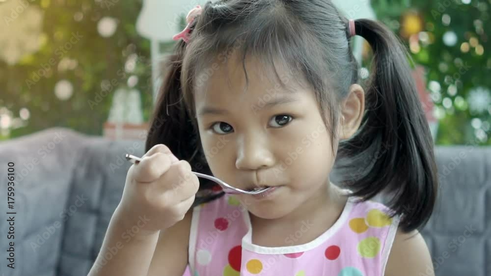 Slow motion, Little asian girl eat chocolate cake with a fork, coffee shop background.
Slow motion, Little asian girl eat chocolate cake with a fork, coffee shop background.