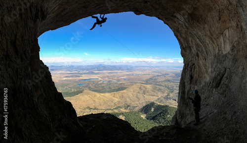 Climber in high mountains at a cave exit