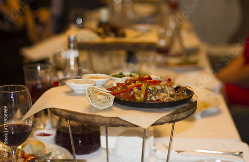 Served dishes to the table for holiday. Cutlery and food on white tablecloths in the restaurant. Design a festive Banquet. Luxurious food for guests and visitors.