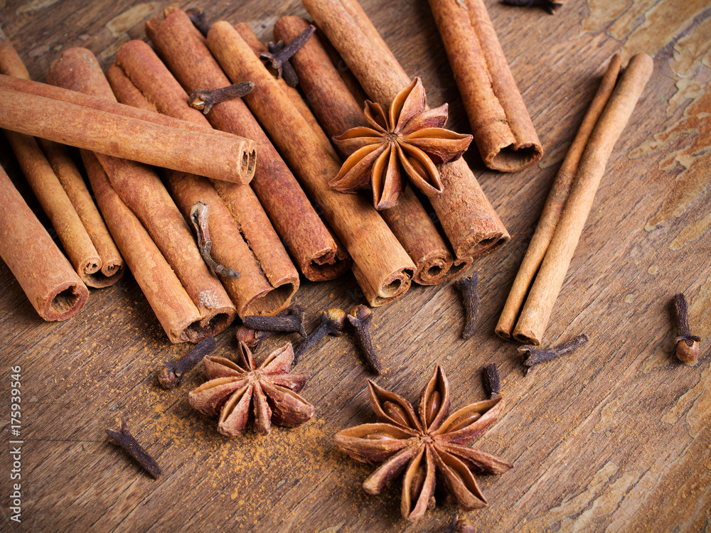 cinnamon sticks, star anise and cloves on wooden background cinnamon sticks, star anise and cloves on wooden background