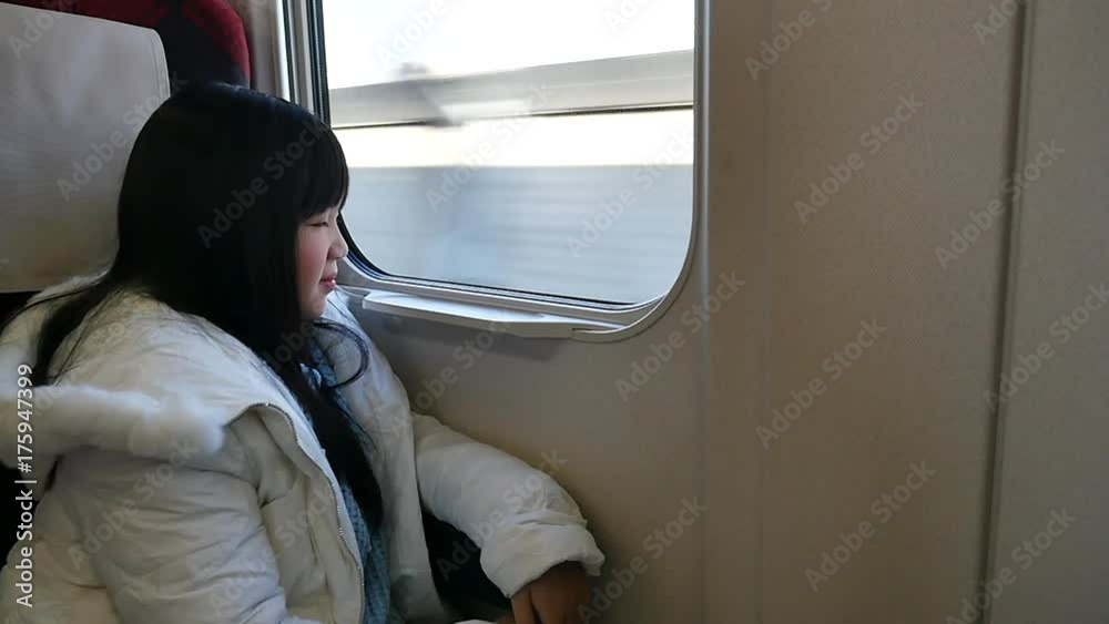 Little asian girl looking through window. She travels on a train slow motion Little asian girl looking through window. She travels on a train slow motion
