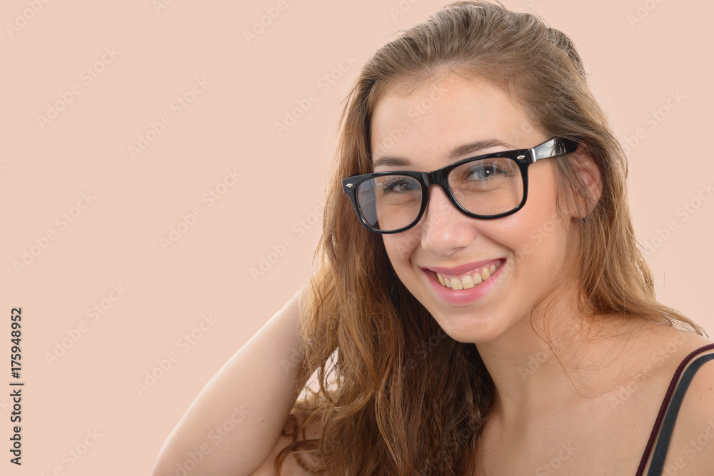 smiling young woman with black glasses, on light pink background smiling young woman with black glasses, on light pink background