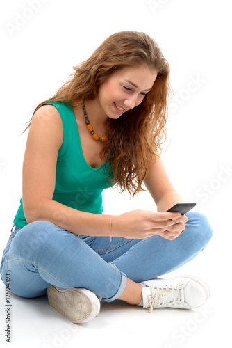 woman in green casual clothing, sitting crossed legs, holding smartphone