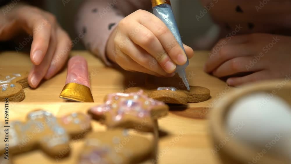 Young mother and her cute little daughter prepare Christmas cookies. Close up of hends Young mother and her cute little daughter prepare Christmas cookies. Close up of hends
