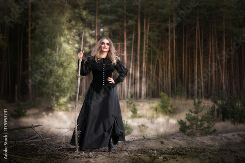 Halloween. beautiful girl witches in the woods with pumpkins