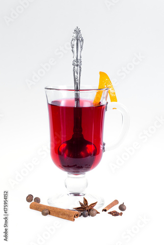 Stack of hot mulled wine with apples and oranges, cloves and vanilla sticks on a white background. Hot Christmas drink.