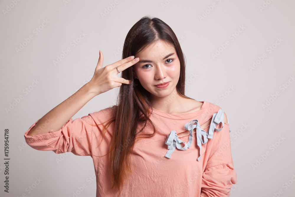 Beautiful young Asian woman holding fingers in gun gesture. Beautiful young Asian woman holding fingers in gun gesture.