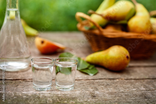 Fototapeta Naklejka Na Ścianę i Meble -  Pear brandy in shot glass.Pears in background.