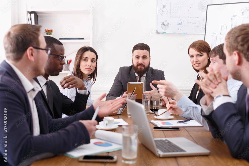 Business meeting of young successful team with male boss in office Business meeting of young successful team with male boss in office
