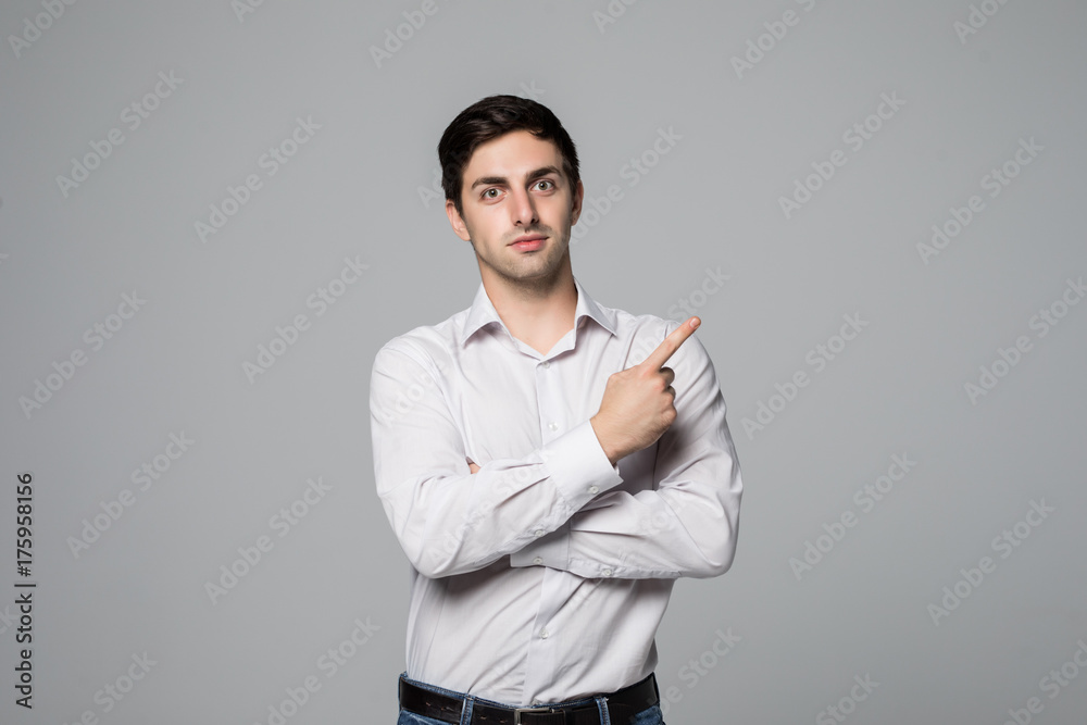 Handsome business man pointing space on gray background Handsome business man pointing space on gray background