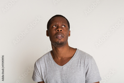 Facial expression, emotions, concentrated black man looking up