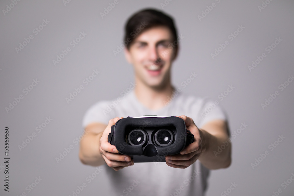 Man wearing virtual reality goggles. Studio shot, gray background Man wearing virtual reality goggles. Studio shot, gray background