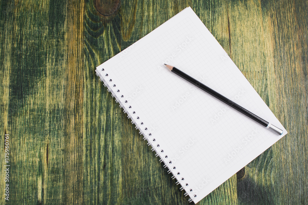 A pencil lying on the notebook A pencil lying on the notebook