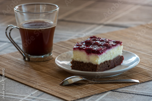 A piece of Black Forest cake on a plate with coffee
