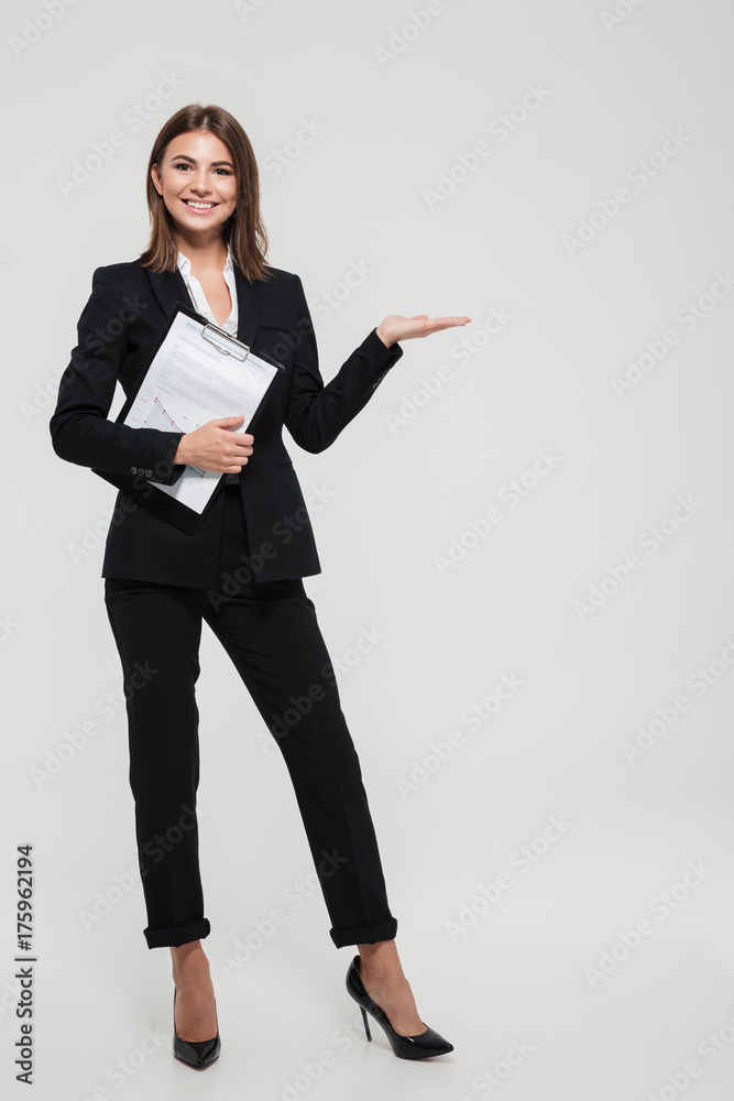 Fotografie Full length portrait of a joyful young businesswoman in suit
