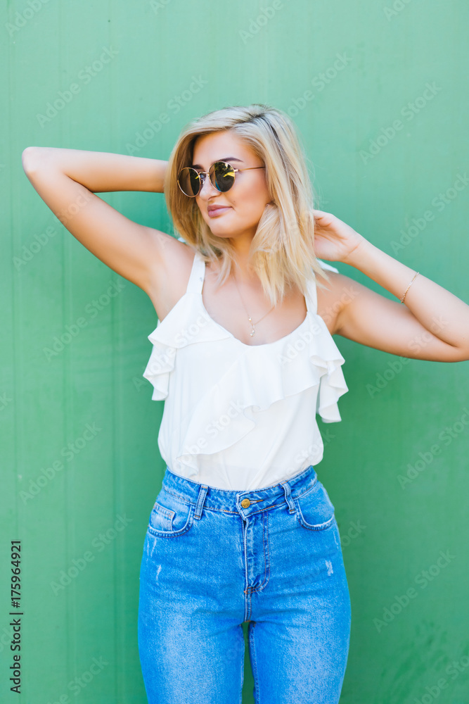 Fun and colorful. Young pretty happy woman in shorts posing against green wall. Fun and colorful. Young pretty happy woman in shorts posing against green wall.