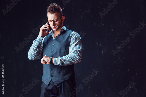 Masculine man in stylish clothes standing and talking phone.