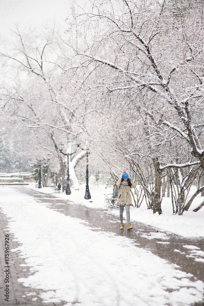 Young woman walking alone in snowy park Young woman walking alone in snowy park