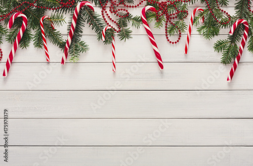 Christmas background with candies and fir tree border on wood