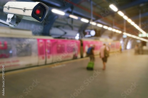 CCTV security indoor camera system operating with people waiting for sky train at train station, transportation, surveillance security and safety technology concept