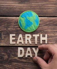 Earth day word with fabric earth globe on wood background, earth day concept