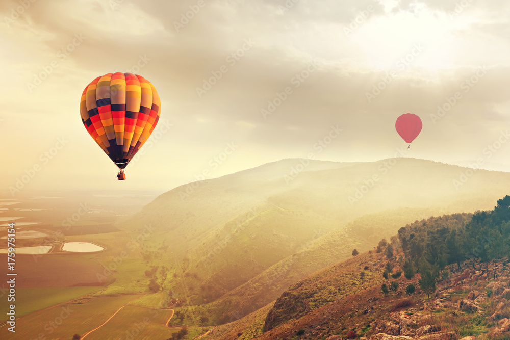 Fototapeta premium Hot Air balloons in the mist sunlight over the mountains of Mount Gilboa, Israel. Adventure and travel