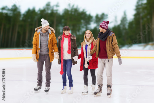 friends holding hands on outdoor skating rink