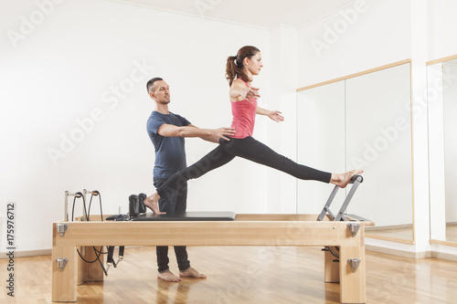 Pilates lesson on reformer  personal coaching young beautiful woman