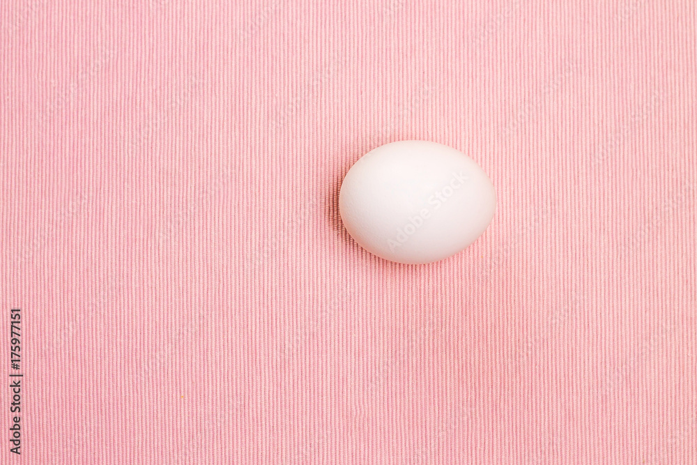 Top view of white egg on the pink background