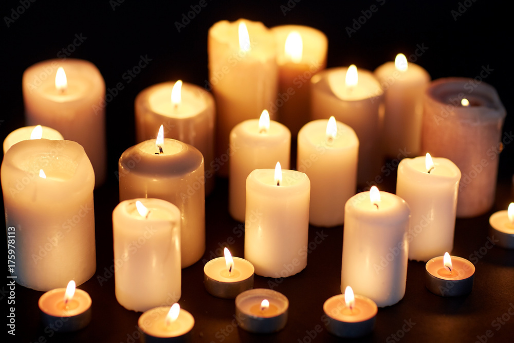 candles burning in darkness over black background candles burning in darkness over black background