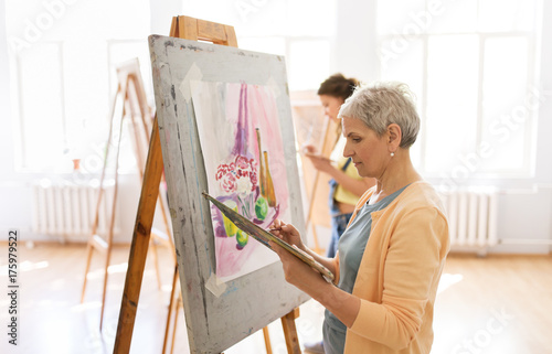 woman artist with easel painting at art school