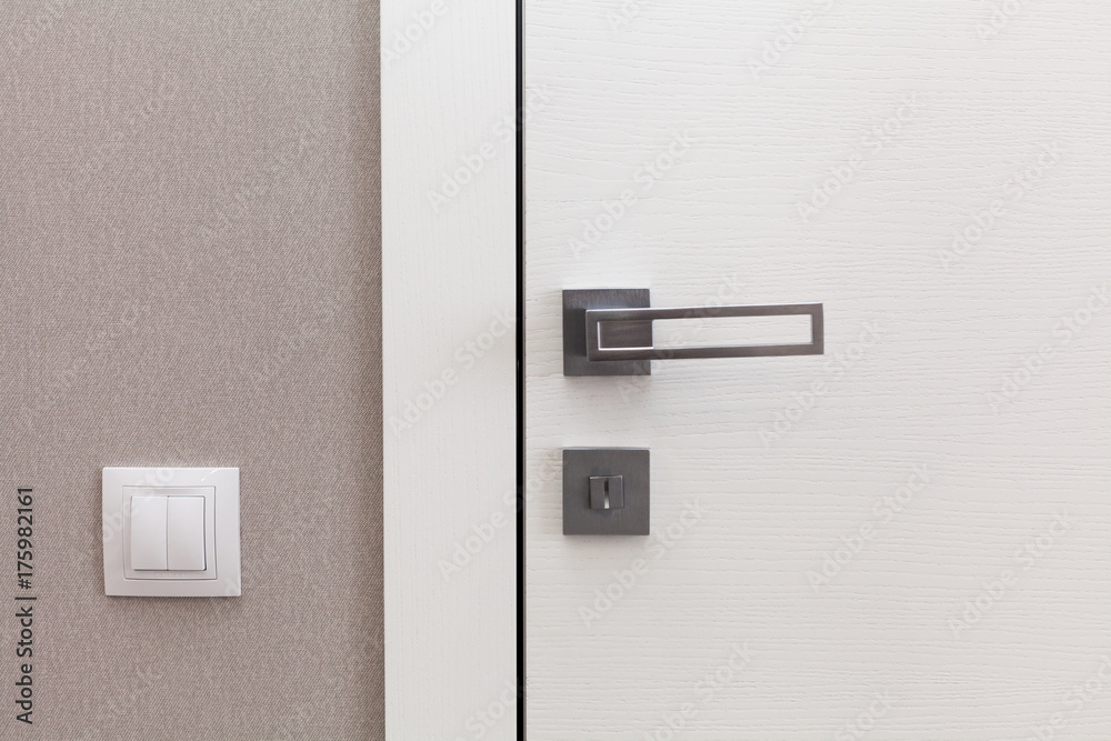 Fototapeta premium Close white door with metallic handle. The door to the bedroom