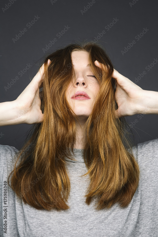 Photo of young redheaded woman with eyes closed Photo of young redheaded woman with eyes closed