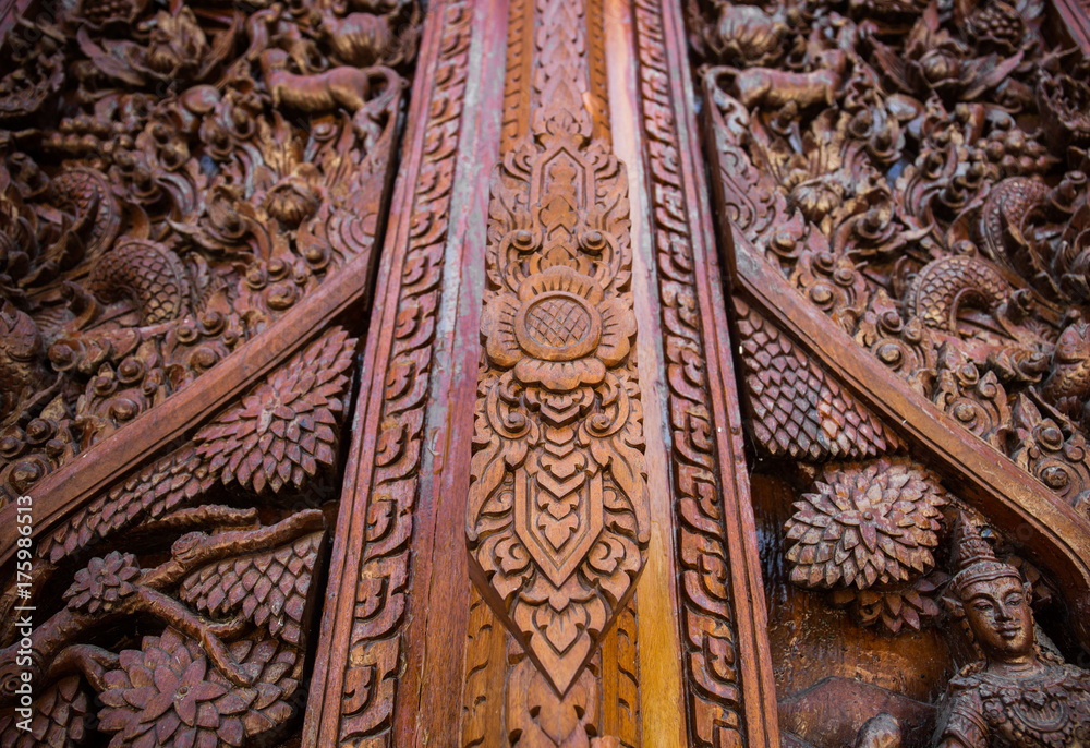 Thai style carve on wooden gate in public temple, countryside, Thailand