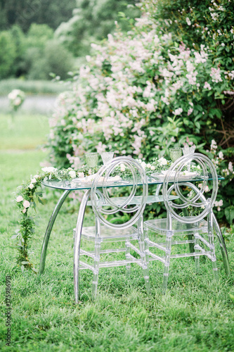 decorated wedding table for two with beautiful flower composition of flowers, glasses for wine, outdoor, fine art. photo