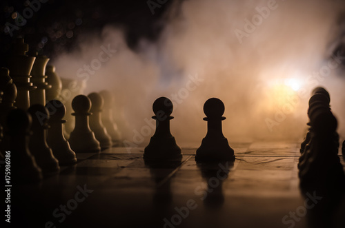 Chess board game concept of business ideas and competition and strategy ideas concep. Chess figures on a dark background with smoke and fog