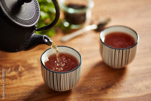 Pouring tea on a tea cup