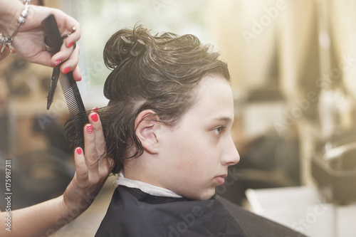 мальчику в парикмахерской делают стрижку