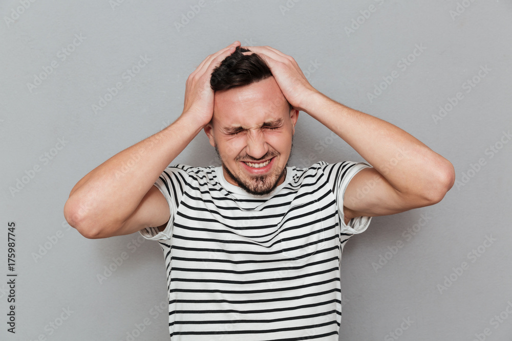 Portrait of a young casual man suffering from a headache Portrait of a young casual man suffering from a headache
